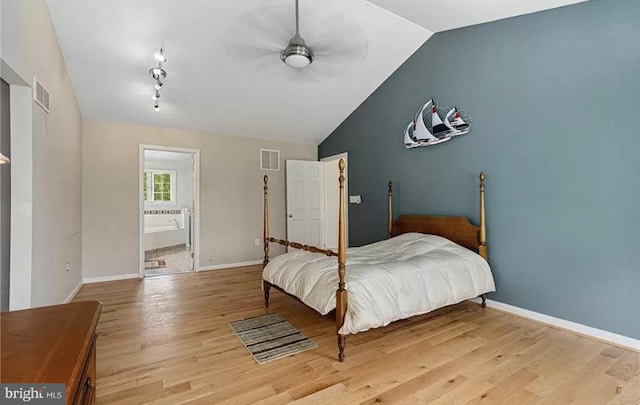 bedroom with light hardwood / wood-style floors, ceiling fan, connected bathroom, and lofted ceiling