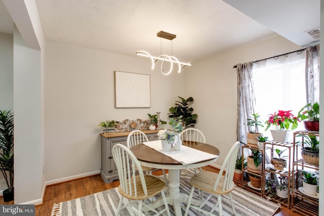 dining room with wood-type flooring and a chandelier