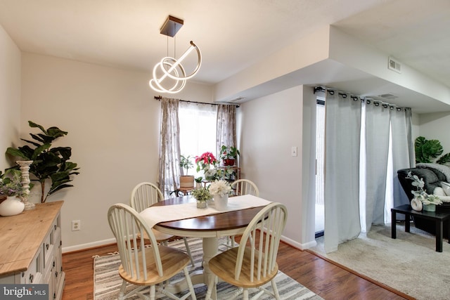 dining room with hardwood / wood-style floors and an inviting chandelier