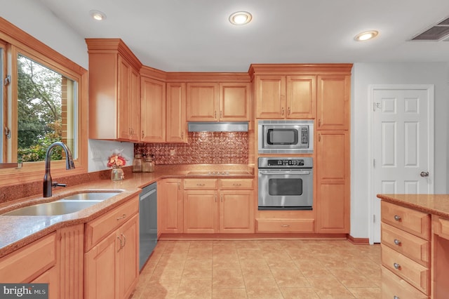 kitchen featuring light brown cabinetry, appliances with stainless steel finishes, tasteful backsplash, light tile patterned floors, and sink