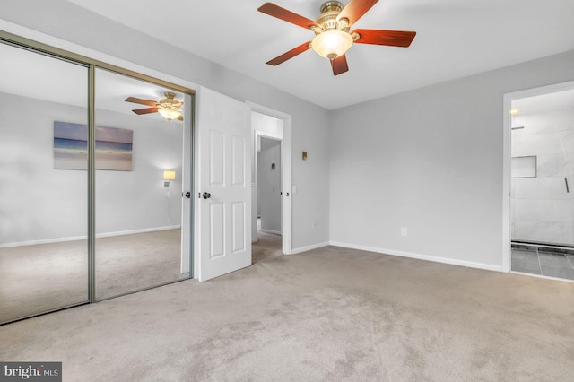 unfurnished bedroom featuring a closet, ceiling fan, and ensuite bath