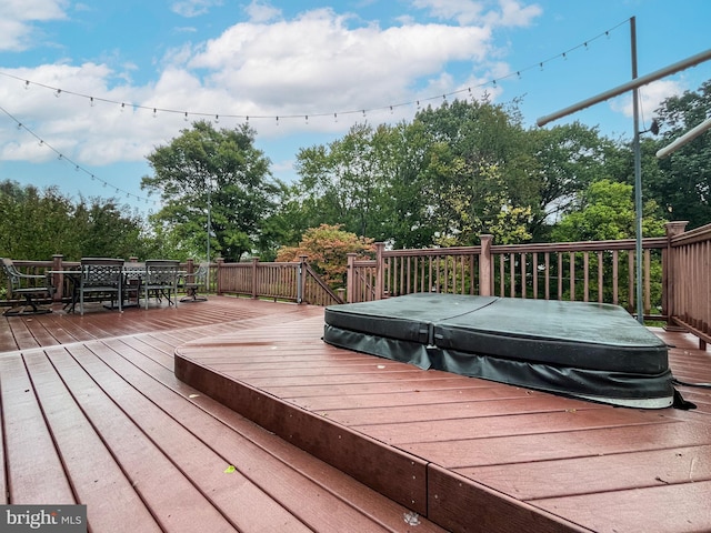 deck featuring a covered hot tub