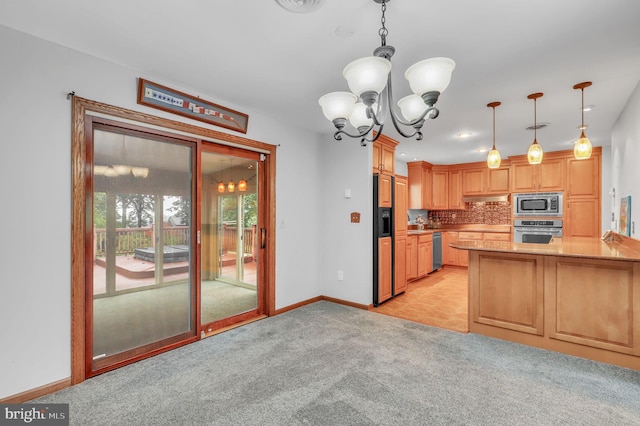 kitchen featuring light brown cabinetry, appliances with stainless steel finishes, a chandelier, light carpet, and kitchen peninsula