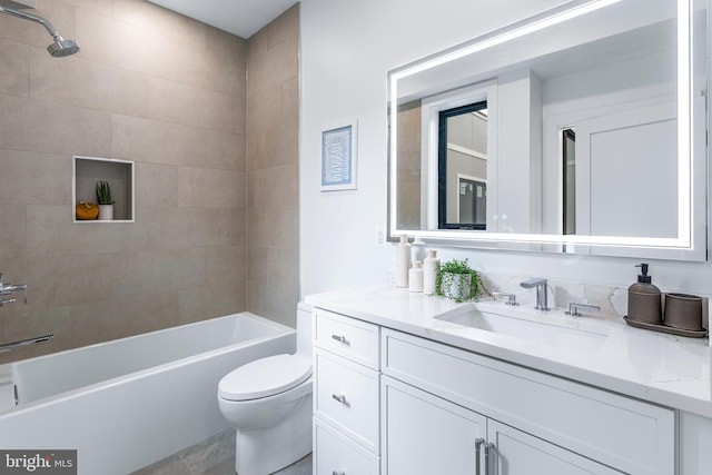 full bathroom featuring toilet, tiled shower / bath combo, and vanity