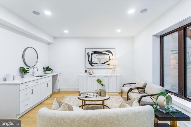 living area with sink and light hardwood / wood-style floors