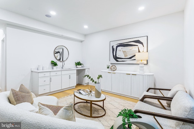 living area with sink and light hardwood / wood-style flooring