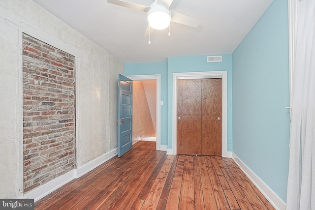 unfurnished bedroom featuring dark wood-type flooring, ceiling fan, and a closet