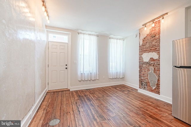 interior space with rail lighting and wood-type flooring