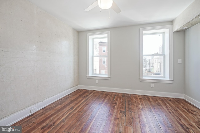 empty room featuring ceiling fan, dark hardwood / wood-style flooring, and a healthy amount of sunlight