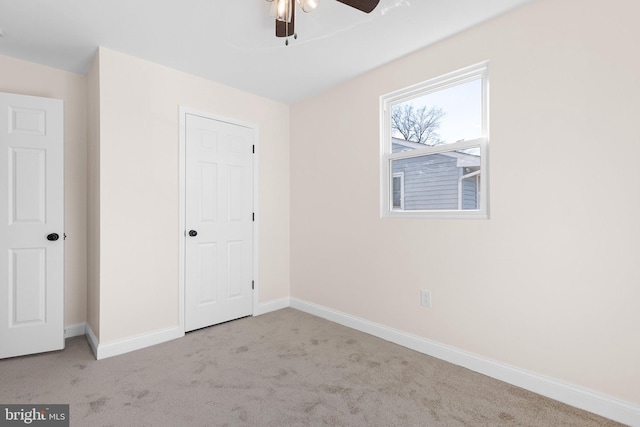 unfurnished bedroom featuring ceiling fan, light colored carpet, and a closet