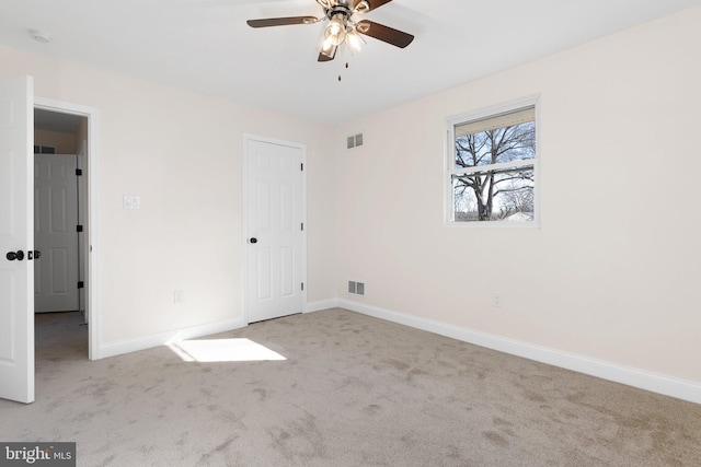 spare room featuring ceiling fan and light carpet