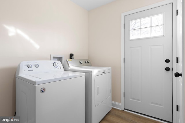 laundry area with washer and clothes dryer and light wood-type flooring