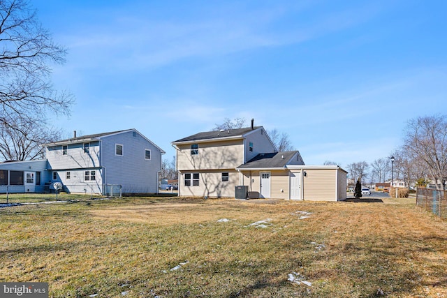 back of house featuring central AC unit and a lawn