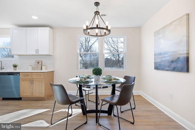 dining area featuring an inviting chandelier and light wood-type flooring