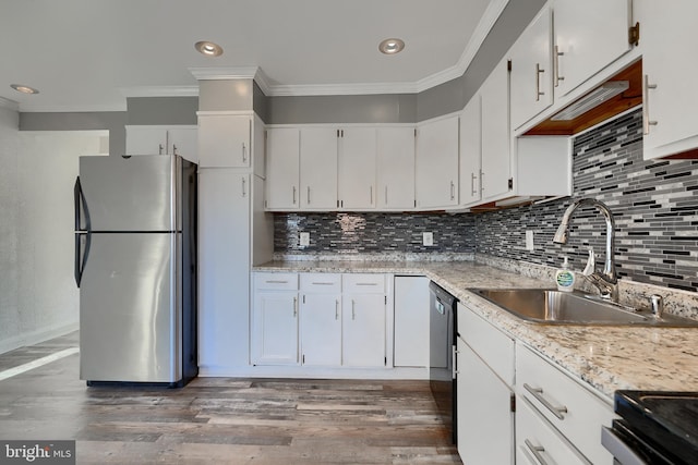 kitchen featuring stainless steel refrigerator, ornamental molding, sink, and white cabinets