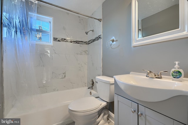 full bathroom featuring tiled shower / bath, vanity, and toilet