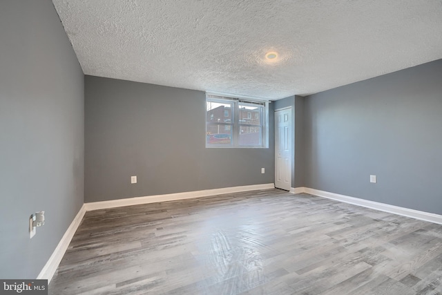 spare room featuring hardwood / wood-style flooring and a textured ceiling