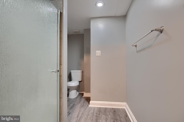 bathroom with hardwood / wood-style flooring and toilet