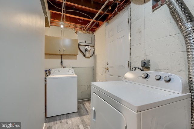 laundry area with washing machine and dryer and light hardwood / wood-style floors