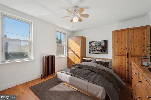 bedroom with radiator, ceiling fan, and light hardwood / wood-style flooring