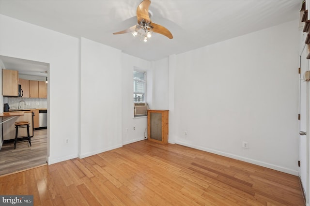 unfurnished living room featuring ceiling fan, sink, cooling unit, and light wood-type flooring