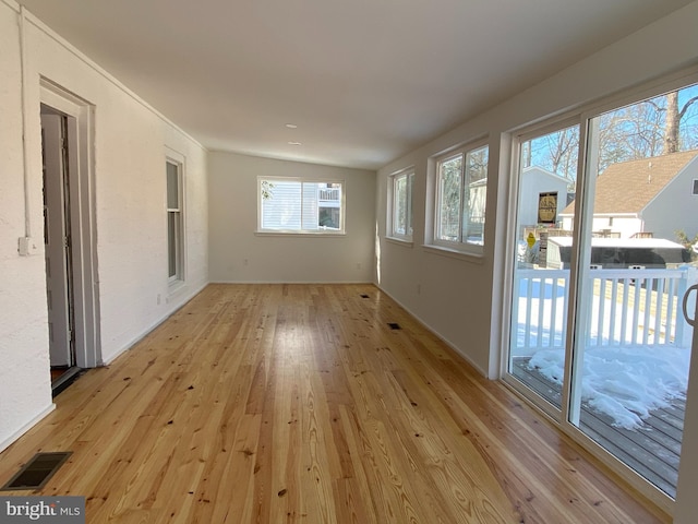 unfurnished room with light hardwood / wood-style flooring and lofted ceiling