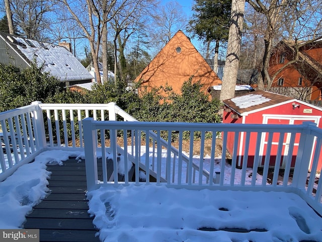 snow covered deck with a shed