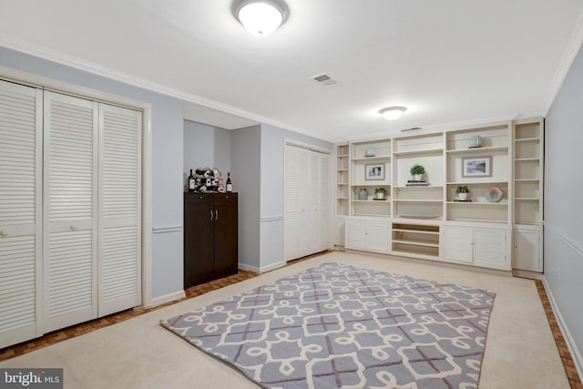 living area with visible vents, crown molding, and baseboards