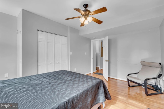 bedroom with baseboards, a closet, a ceiling fan, and wood finished floors