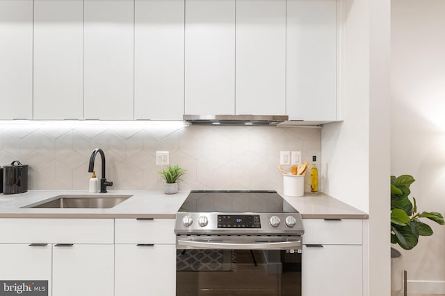 kitchen with sink, white cabinetry, electric range, and tasteful backsplash