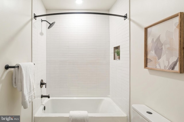 bathroom with toilet and tiled shower / bath combo