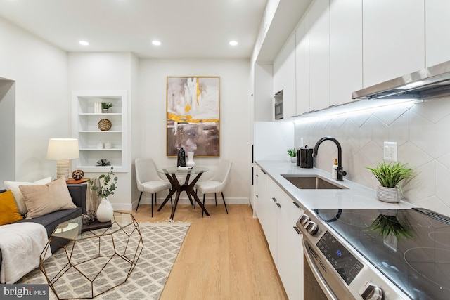 kitchen featuring sink, white cabinets, light wood-type flooring, and appliances with stainless steel finishes