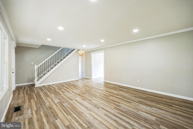 unfurnished living room featuring ornamental molding and light wood-type flooring