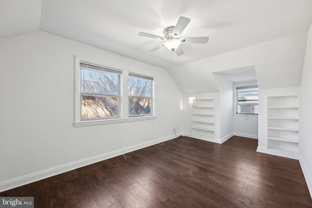 additional living space featuring vaulted ceiling, dark hardwood / wood-style floors, cooling unit, ceiling fan, and built in shelves