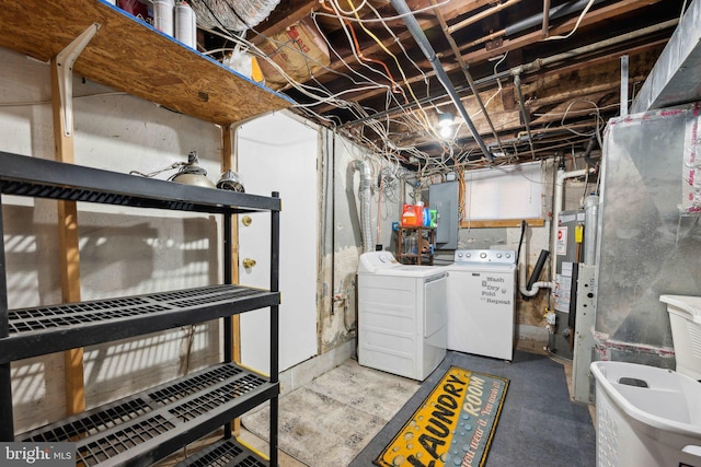 laundry room with gas water heater, electric panel, and washing machine and dryer