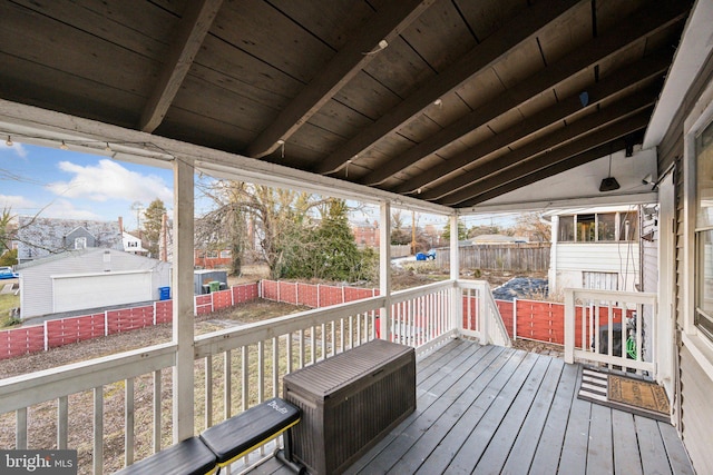 wooden terrace featuring a garage and an outdoor structure