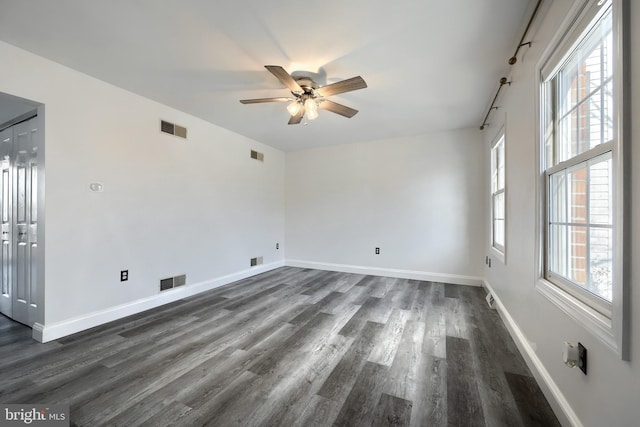 spare room with dark wood-type flooring and ceiling fan