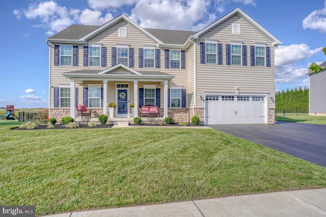 view of front of house featuring a front yard, a garage, and a porch