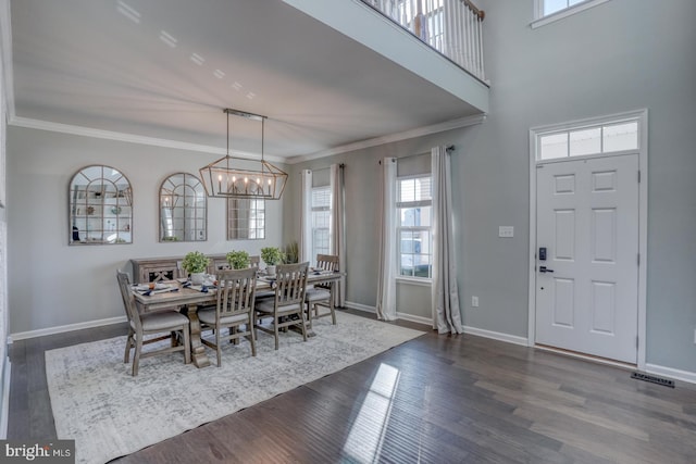 dining area with a chandelier, ornamental molding, and dark hardwood / wood-style floors