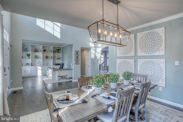 dining room featuring a notable chandelier, ornamental molding, built in features, and hardwood / wood-style flooring