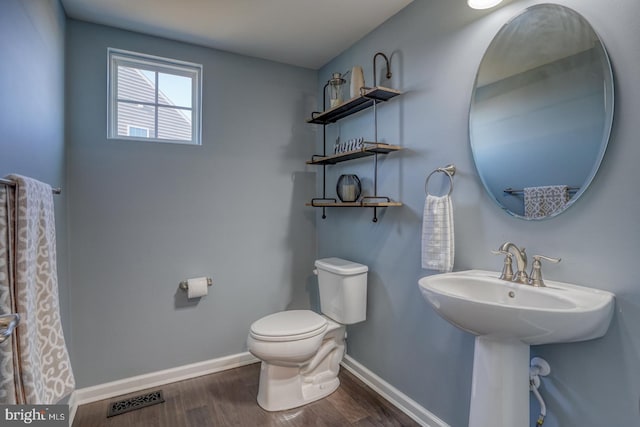 bathroom with sink, toilet, and wood-type flooring