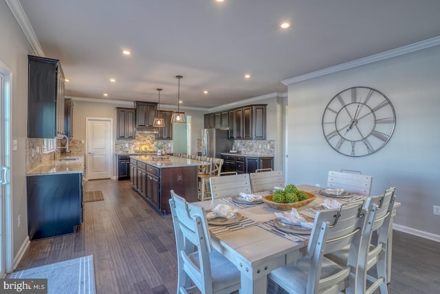 dining space featuring sink, dark hardwood / wood-style flooring, and ornamental molding