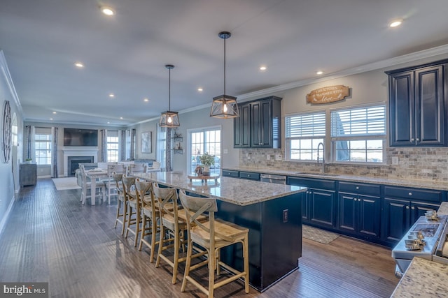 kitchen with sink, blue cabinets, a breakfast bar area, and a center island