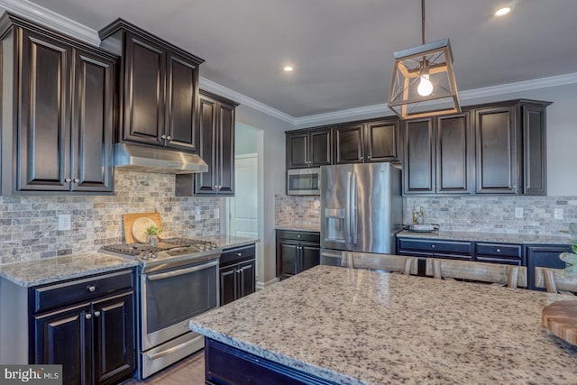 kitchen with appliances with stainless steel finishes, ornamental molding, pendant lighting, and decorative backsplash