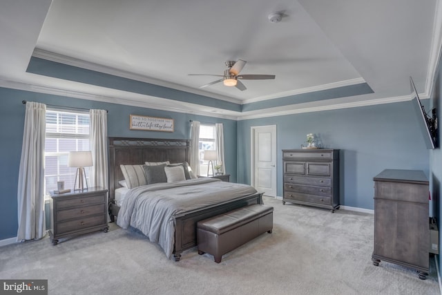 bedroom with light carpet, ceiling fan, and a tray ceiling