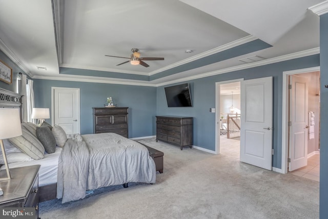 bedroom featuring ensuite bath, a raised ceiling, ceiling fan, and light carpet