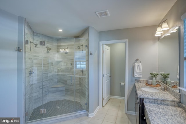 bathroom featuring tile patterned flooring, a shower with shower door, and vanity