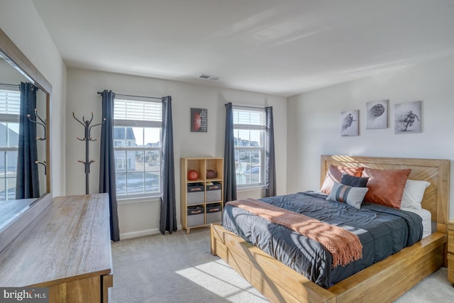 bedroom featuring light colored carpet and multiple windows