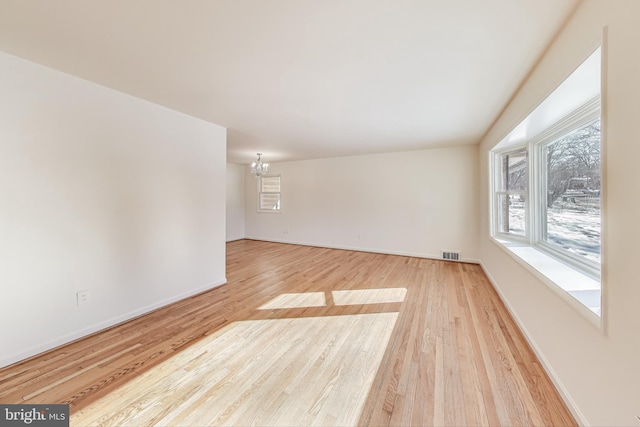 unfurnished room featuring light hardwood / wood-style floors and a chandelier