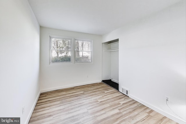 unfurnished bedroom with a closet and light hardwood / wood-style floors